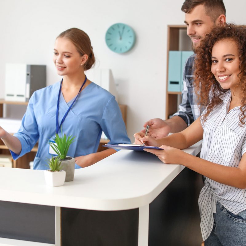 Young woman near reception desk in clinic